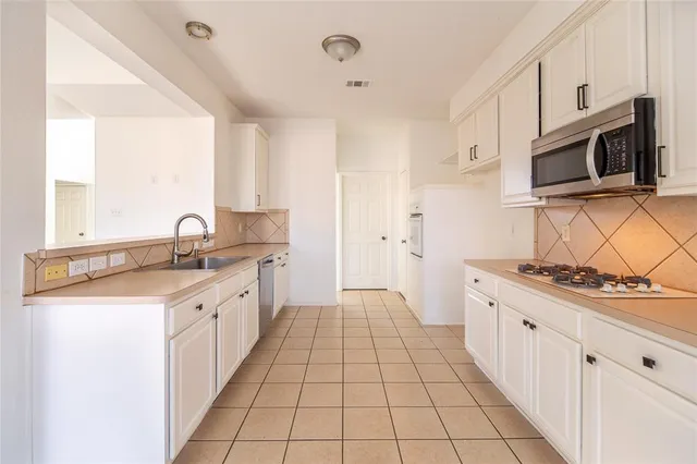 a kitchen with stainless steel appliances a sink stove and cabinets