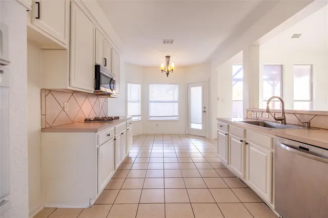 a kitchen with stainless steel appliances granite countertop a sink and a stove