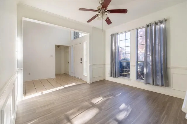 a view of an empty room with window and wooden floor