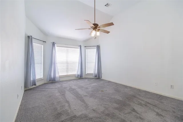 a view of a room with a ceiling fan and a window
