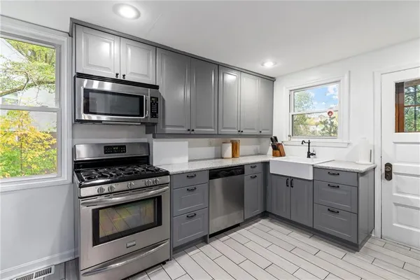 a kitchen with stainless steel appliances granite countertop a stove microwave and sink