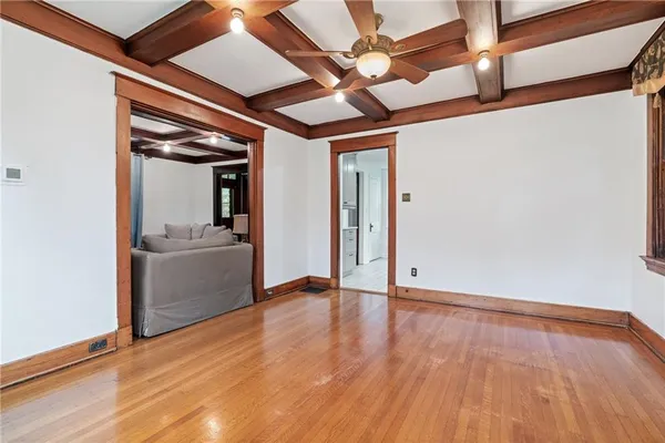 a view of an empty room with a window and wooden floor