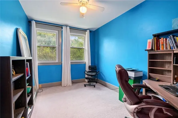 a view of a workspace with furniture and a window