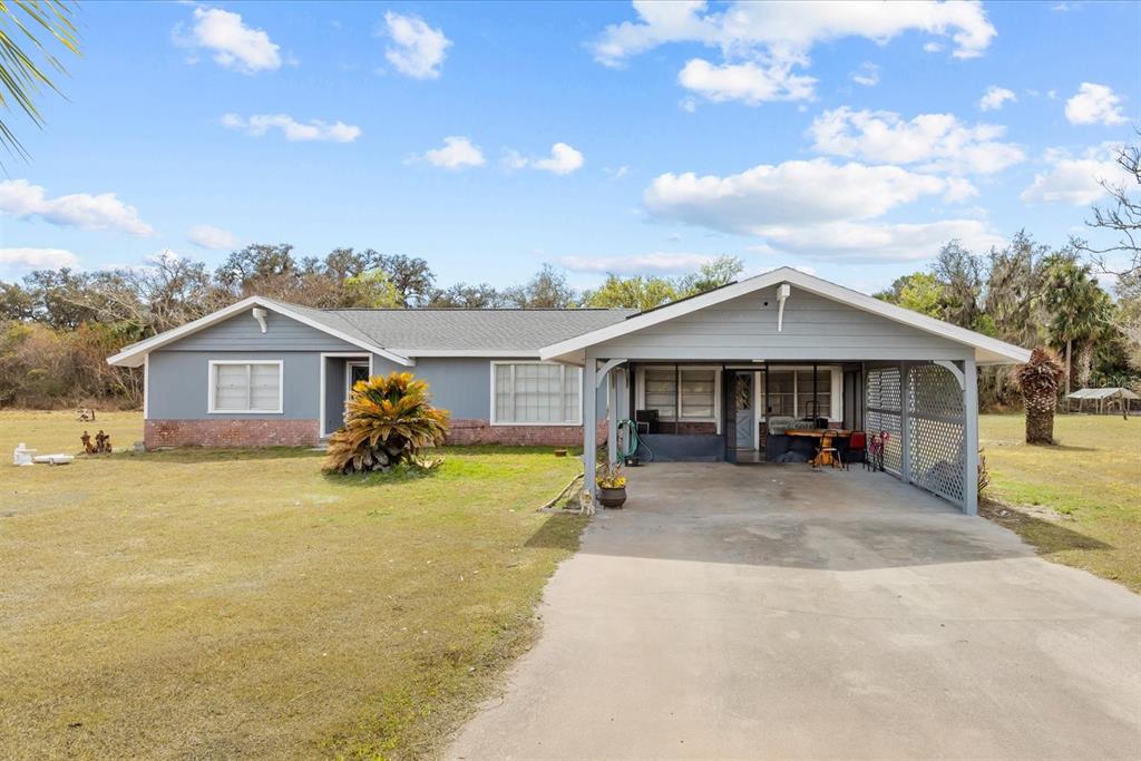 31300 Highway 441 Okeechobee, FL 34972 - Photo 2 of 33 a front view of a house with a yard and garage
