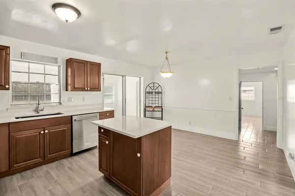 a large kitchen with stainless steel appliances granite countertop a sink and wooden floors