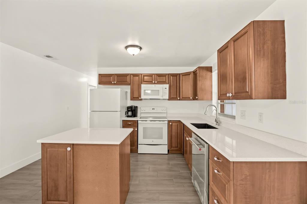 31300 Highway 441 Okeechobee, FL 34972 - Photo 10 of 33 a kitchen with a sink a stove top oven and white stainless steel appliances