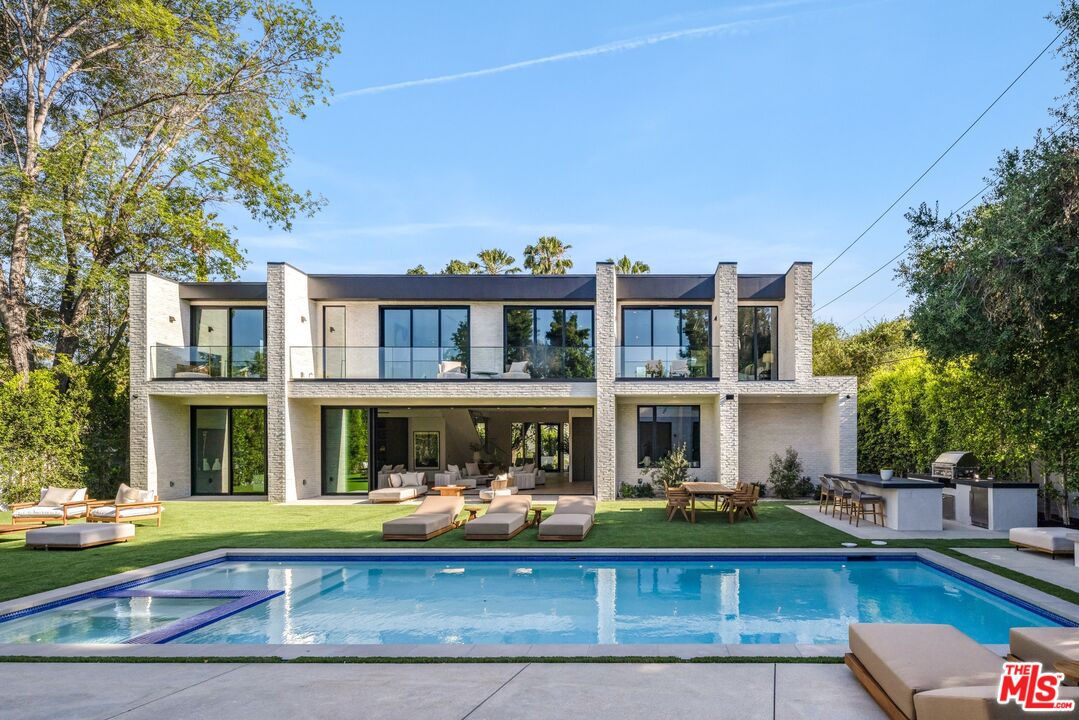 17055 Rancho Street Encino, CA 91316 - Photo 45 of 73 a front view of building with yard swimming pool and outdoor seating