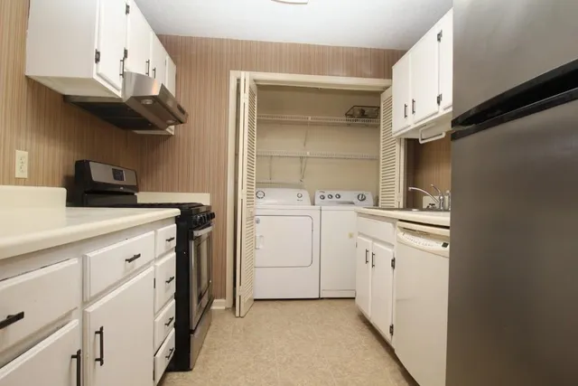 a utility room with cabinets washer and dryer