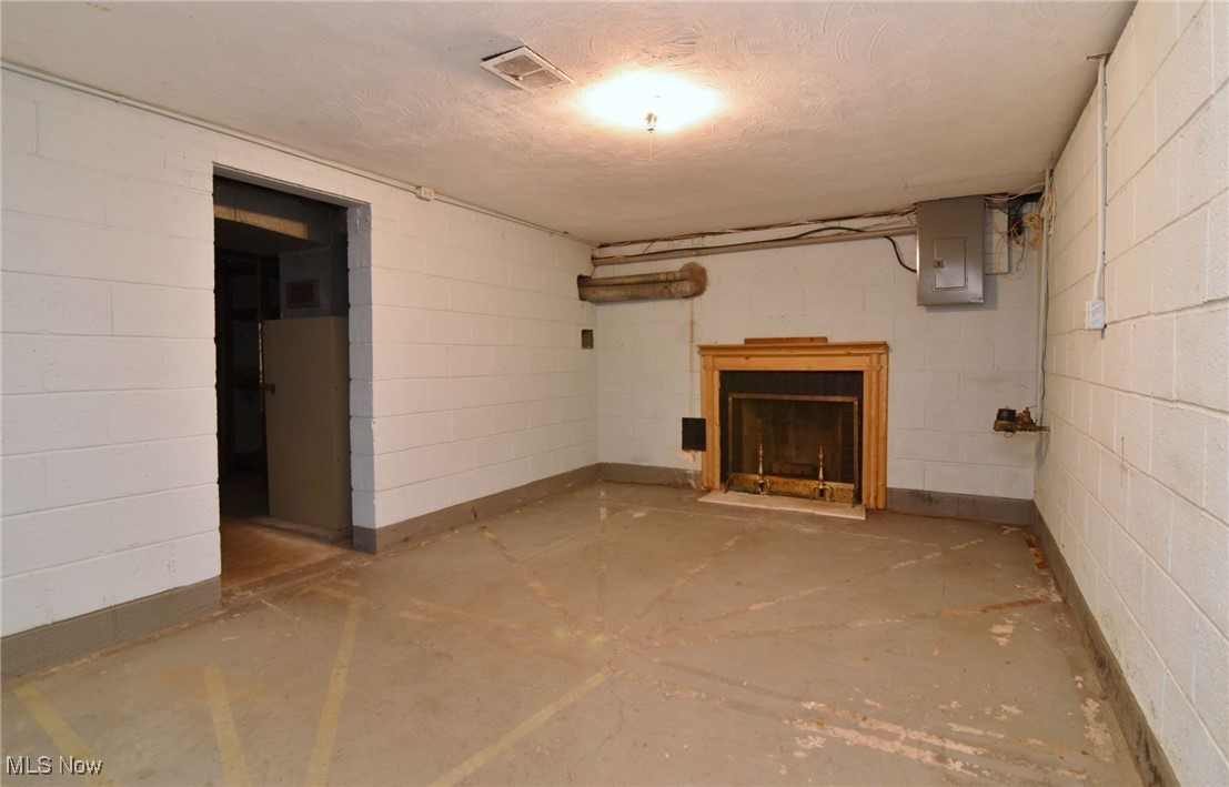 6308 Highland Road Cleveland, OH 44143 - Photo 35 of 40 Unfinished below grade area featuring visible vents, a fireplace, electric panel, and concrete block wall