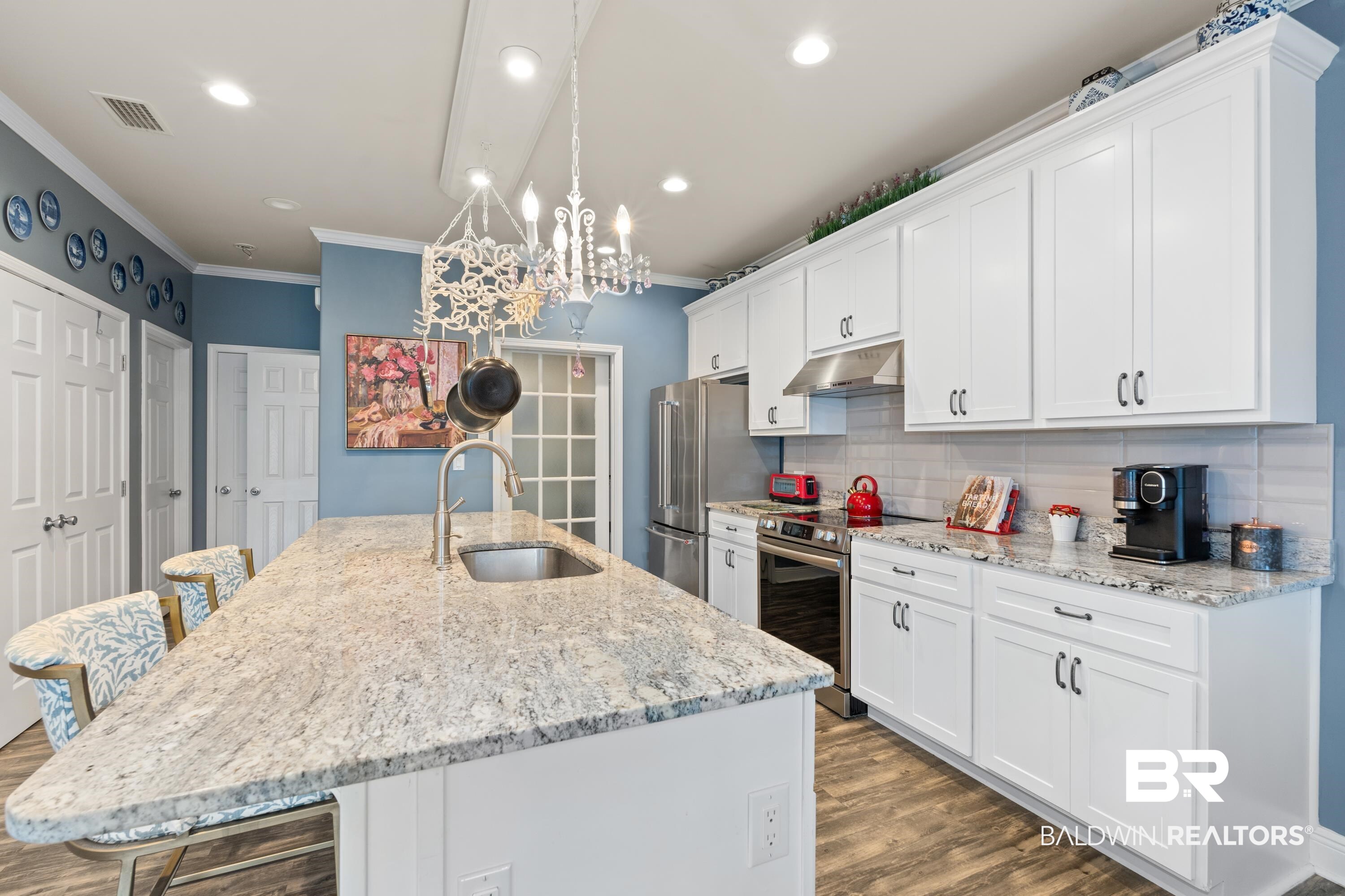 1113 Yellow Daisy Lane Foley, AL 36535 - Photo 13 of 35 Kitchen featuring crown molding, tasteful backsplash, stainless steel appliances, a kitchen island with sink, and wood finished floors
