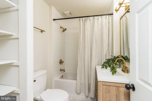a white toilet sitting next to a white tub