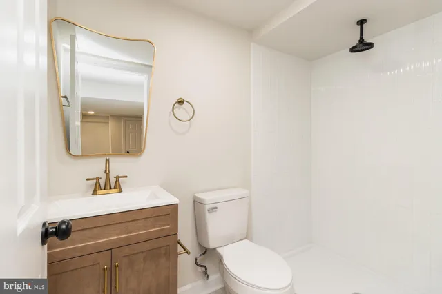 a bathroom with a toilet a sink and mirror