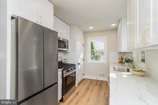 a kitchen with stainless steel appliances a refrigerator a stove a sink cabinets and a counter top space