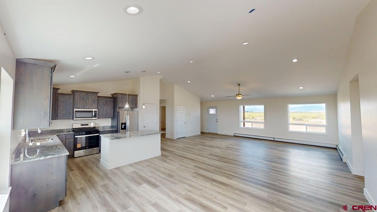 8714 Ridgetop Drive Alamosa, CO 81101 - Photo 7 of 18 a large kitchen with stainless steel appliances lots of counter space and a wooden floor