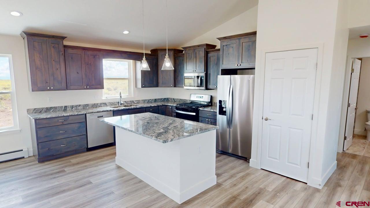 8714 Ridgetop Drive Alamosa, CO 81101 - Photo 8 of 18 a kitchen with stainless steel appliances granite countertop a refrigerator and a stove top oven