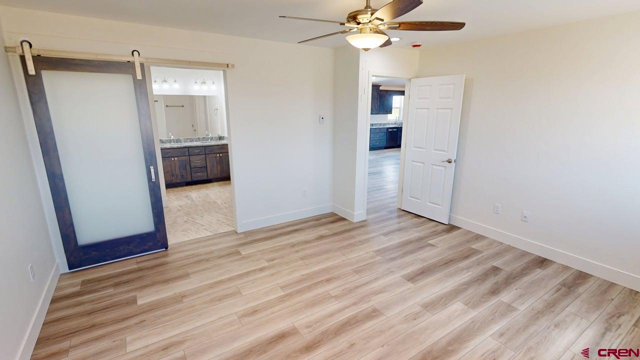 8714 Ridgetop Drive Alamosa, CO 81101 - Photo 10 of 18 wooden floor in an empty room with a mirror