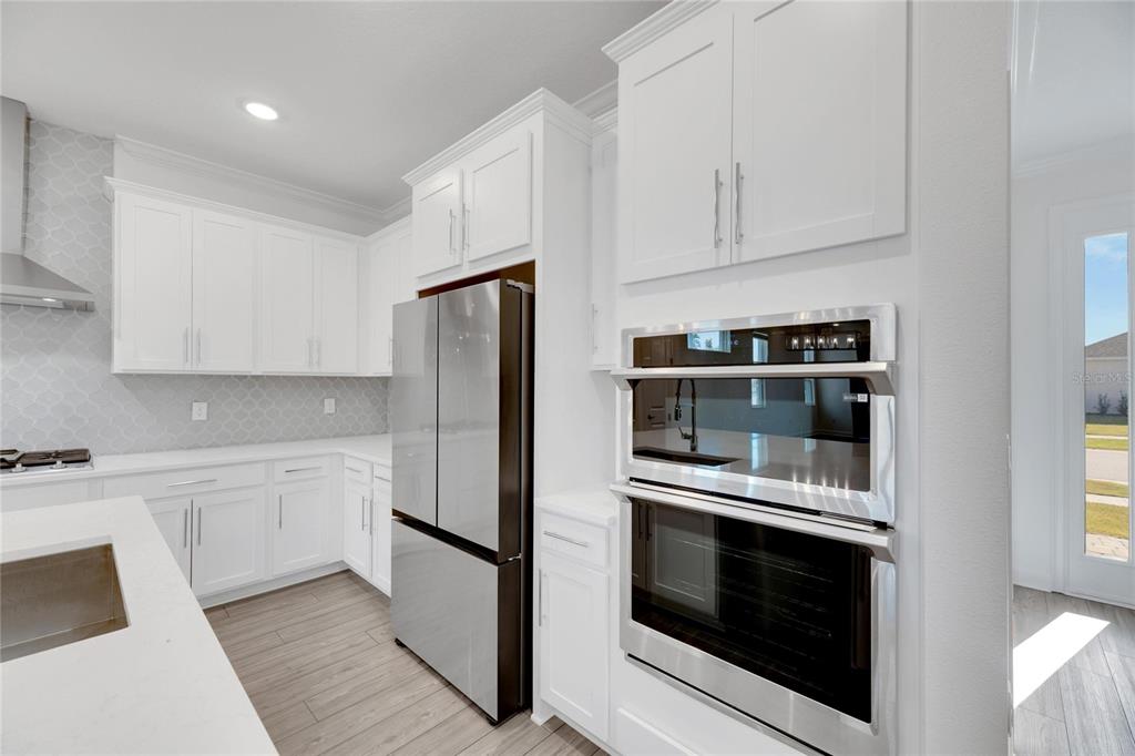 923 Signet Drive Apollo Beach, FL 33572 - Photo 22 of 84 a kitchen with stainless steel appliances white cabinets and wooden floors