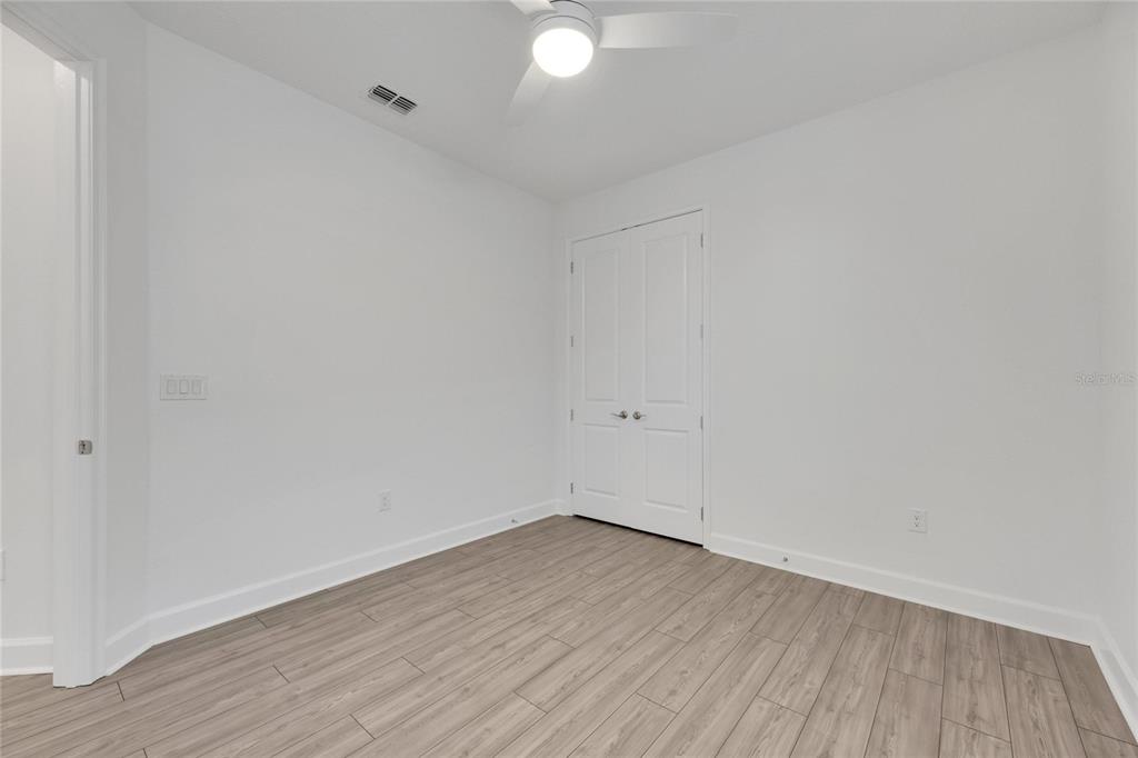 923 Signet Drive Apollo Beach, FL 33572 - Photo 48 of 84 a view of an empty room with wooden floor and fan