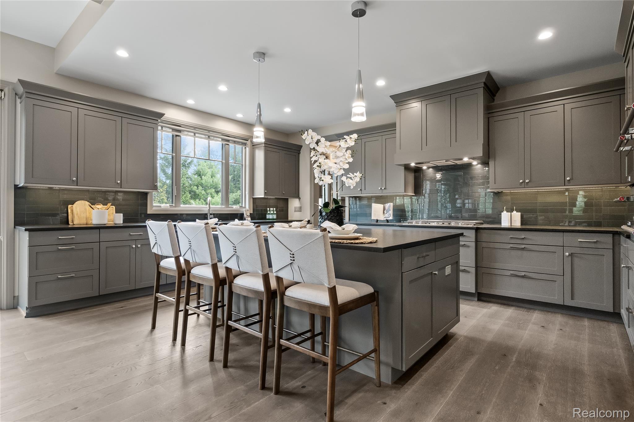 3824 Poppleton Street Troy, MI 48084 - Photo 12 of 51 Kitchen with a breakfast bar area, gray cabinetry, a center island, decorative light fixtures, and decorative backsplash