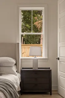 an empty room with wooden floor windows and ceiling fan