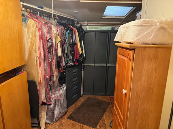 a view of walk in closet with clothes and shoes