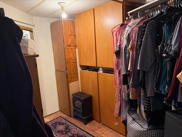 a bed sitting in a bedroom next to a window and a lamp
