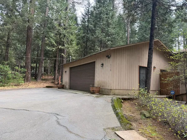 a view of a house with backyard and trees