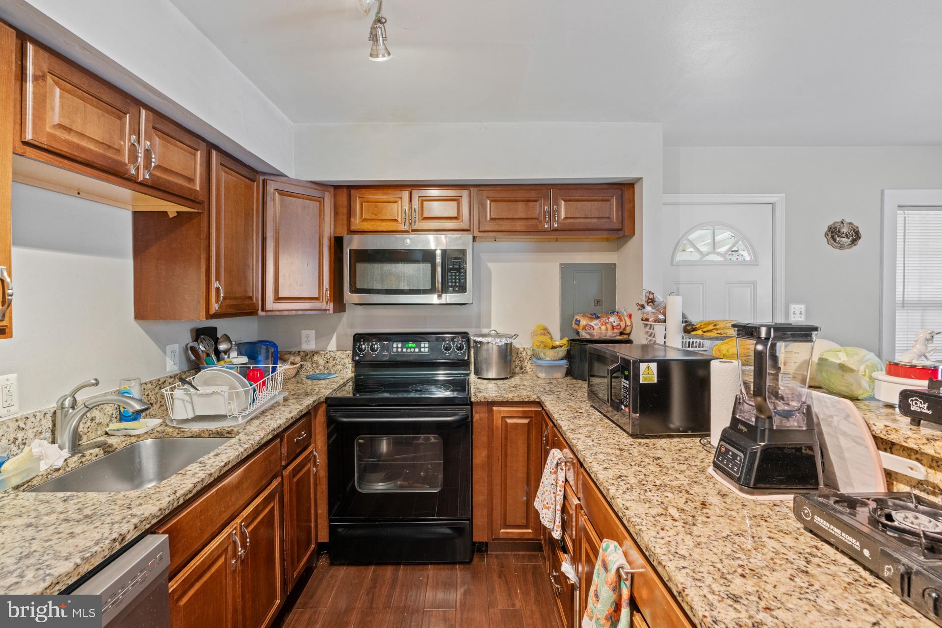 9315 Byrd Drive Manassas, VA 20110 - Photo 23 of 27 a kitchen with a stove top oven a sink a dining table and chairs
