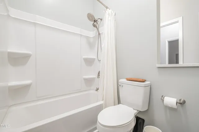 a white toilet sitting next to a bath tub