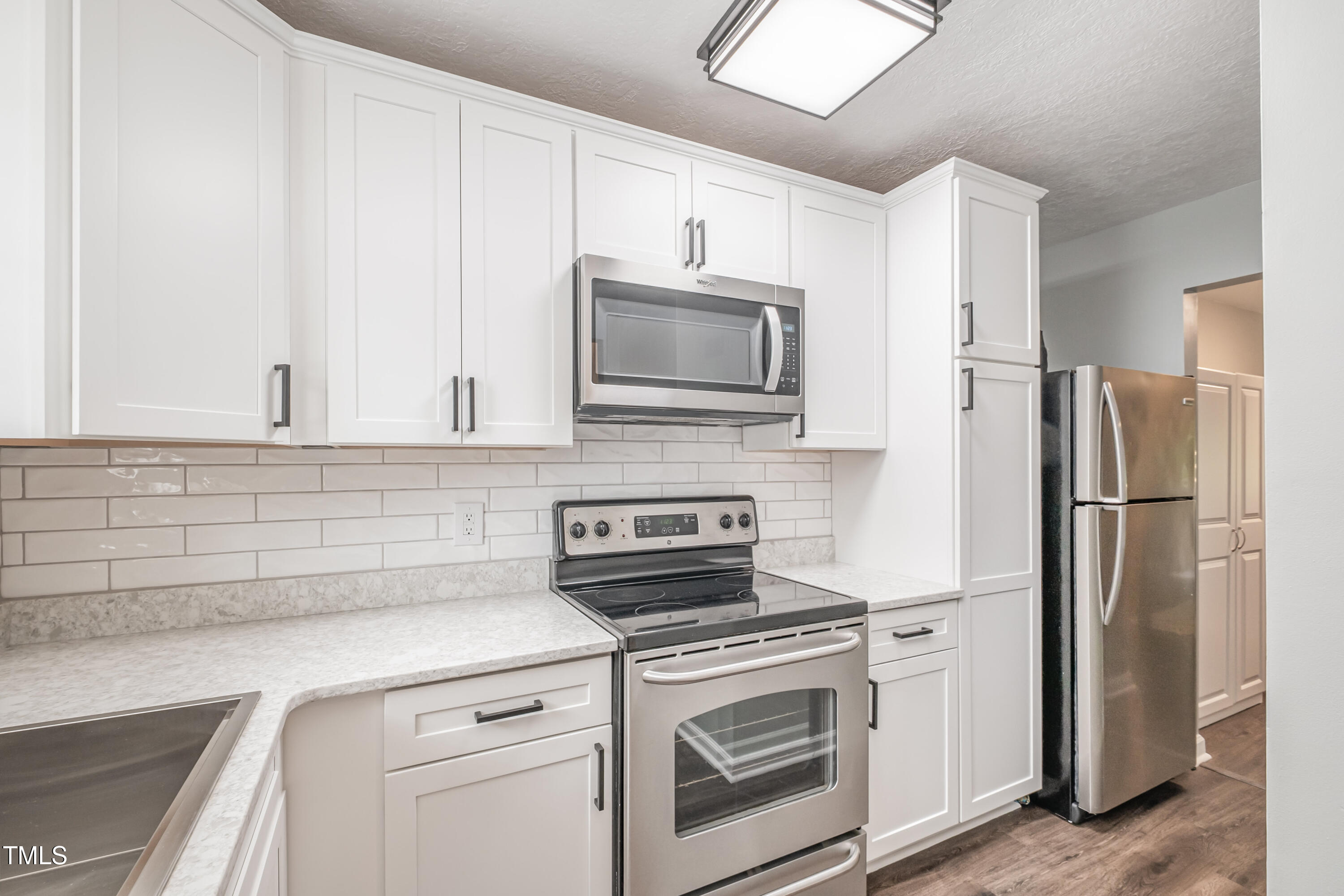 932 South 5th Street Mebane, NC 27302 - Photo 10 of 29 a kitchen with stainless steel appliances white cabinets and a refrigerator