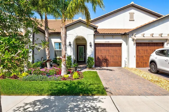 a front view of a house with a garden and plants