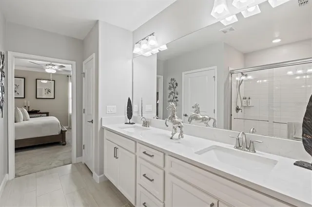 a spacious en suite bathroom with double sink and a mirror