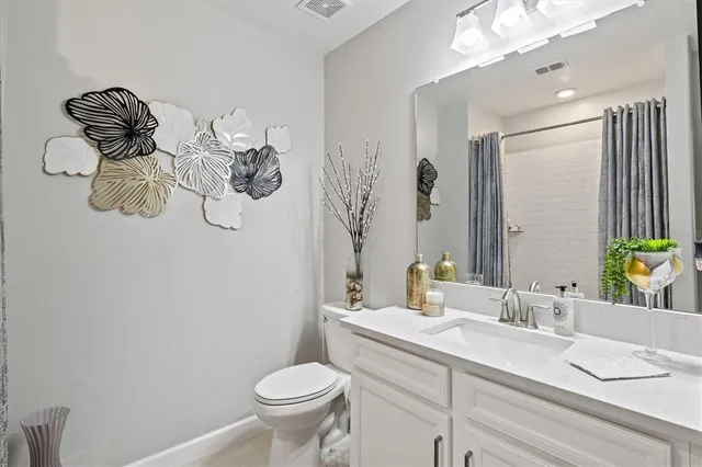 a bathroom with a granite countertop sink a toilet and mirror