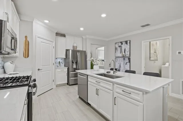 a kitchen with a refrigerator a sink and wooden cabinets