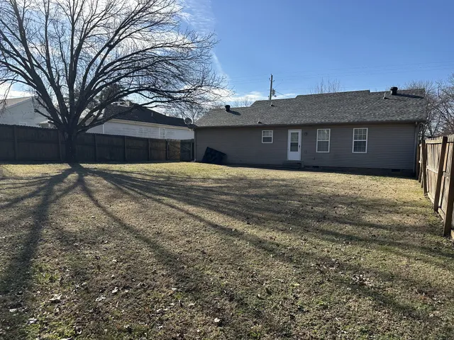 a front view of a house with yard and trees