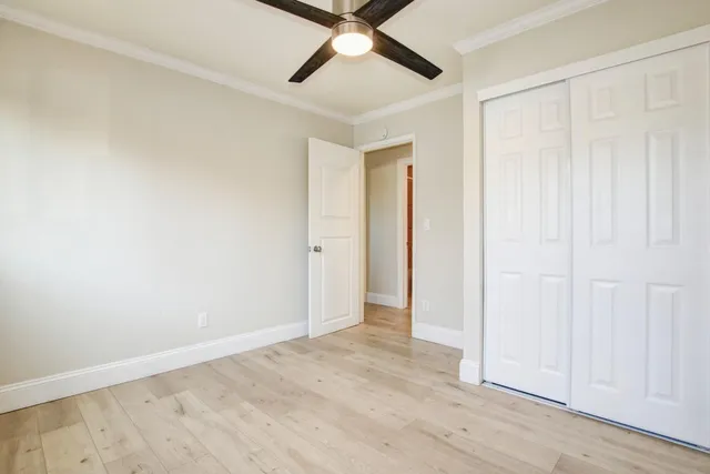 an empty room with a window and a fan