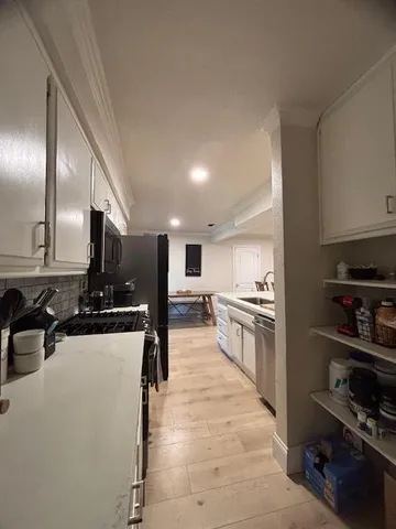a kitchen with a stove and a flat screen tv