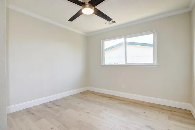 a view of empty room with wooden floor