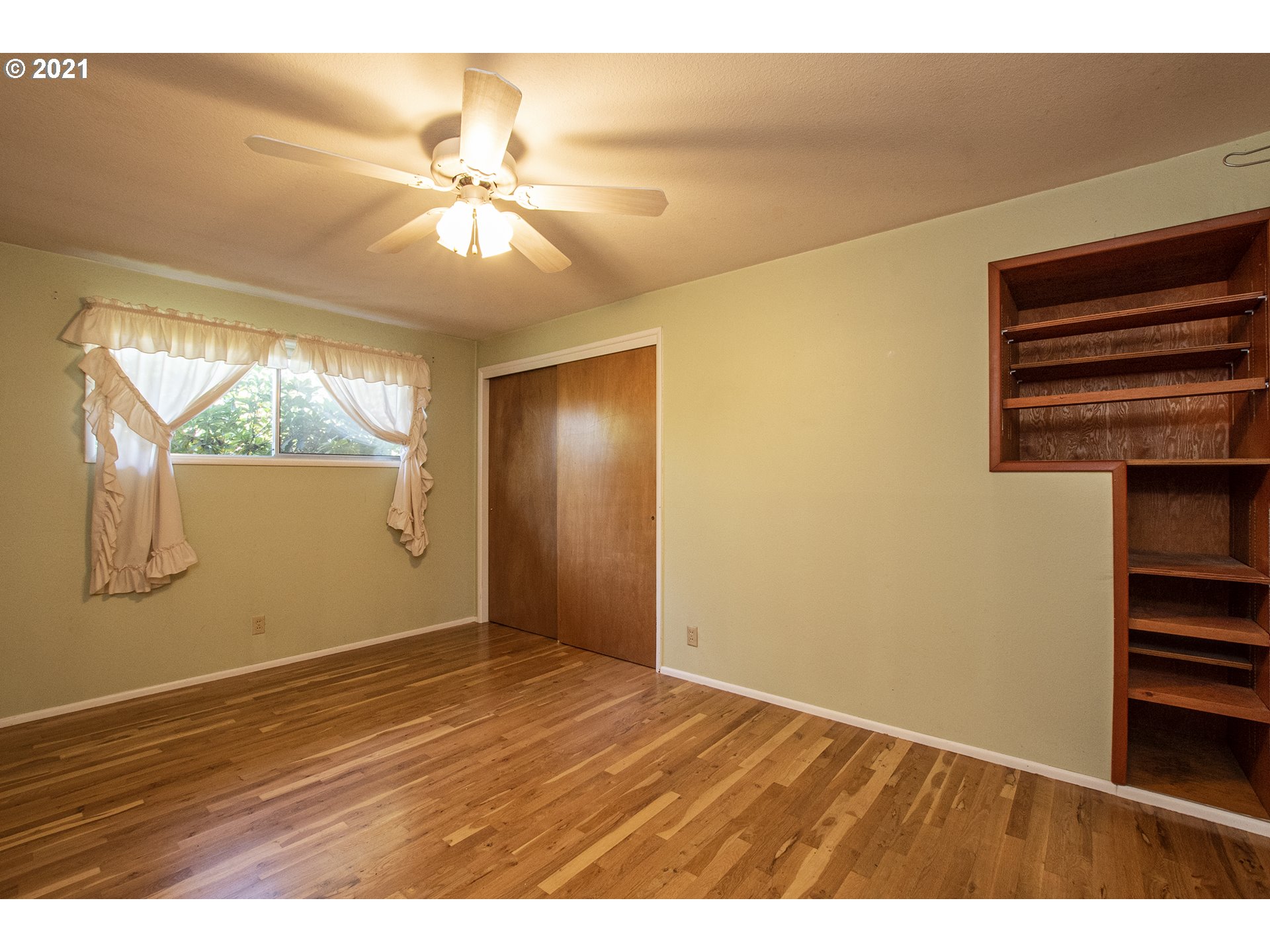 1366 N Street Springfield, OR 97477 - Photo 13 of 28 an empty room with wooden floor fan and windows