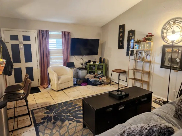a living room with furniture a flat screen tv and a floor to kitchen