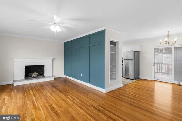 a view of empty room with wooden floor and fireplace