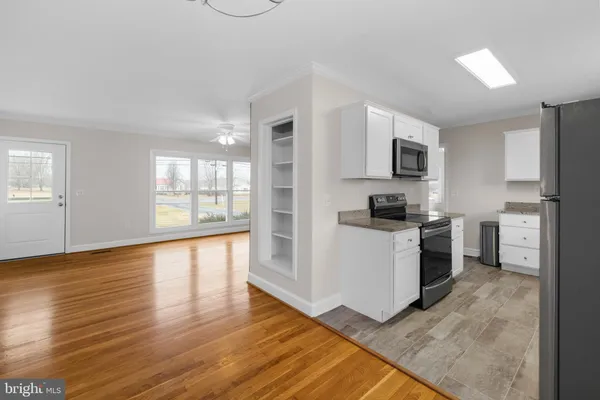 a kitchen with granite countertop a refrigerator stove top oven and cabinets