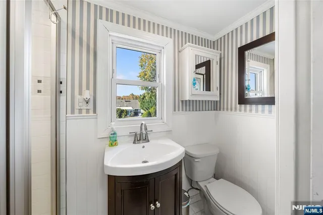 a bathroom with a toilet a sink and a mirror