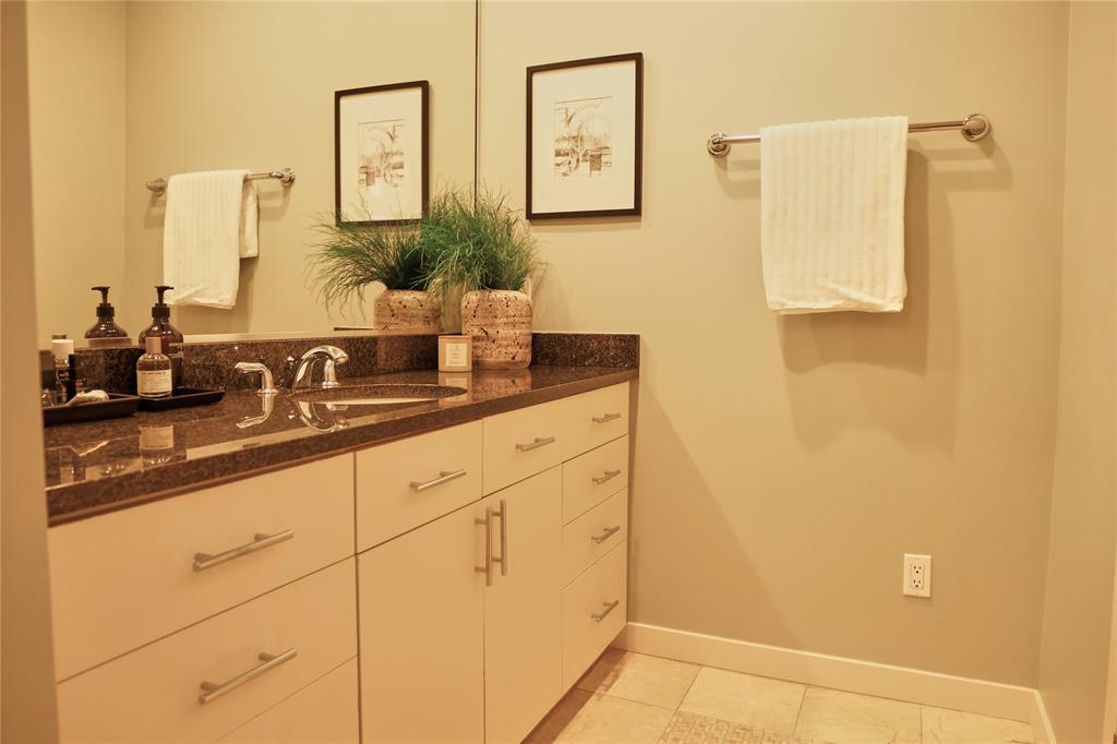 4026 Travis Street, Unit E Dallas, TX 75204 - Photo 13 of 19 a bathroom with a double vanity sink and a mirror