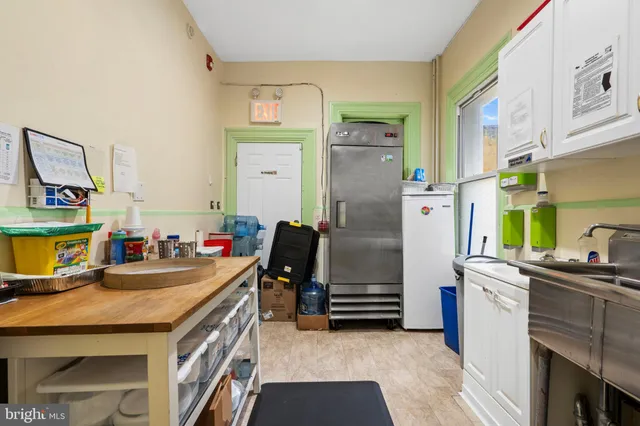 a kitchen that has a kitchen island wooden cabinets and stainless steel appliances