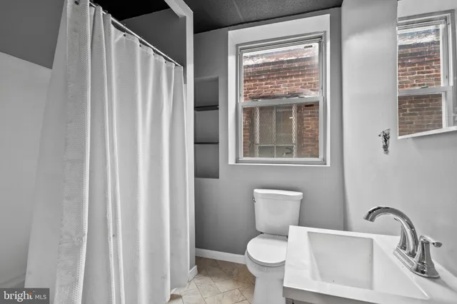 a bathroom with a toilet a sink and a window