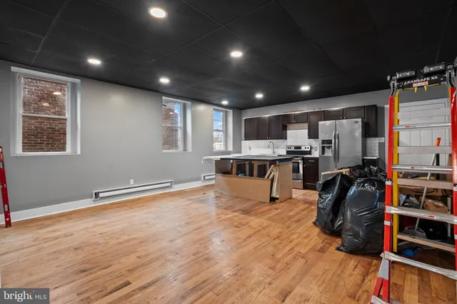 a view of kitchen with stainless steel appliances refrigerator oven and cabinets