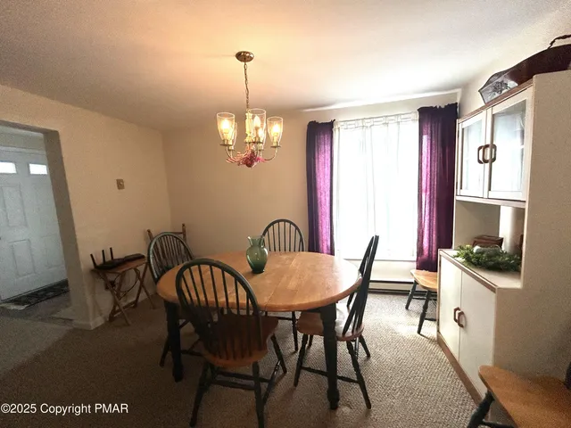 a view of a dining room with furniture and chandelier
