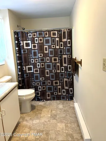 a bathroom with a toilet and a shower
