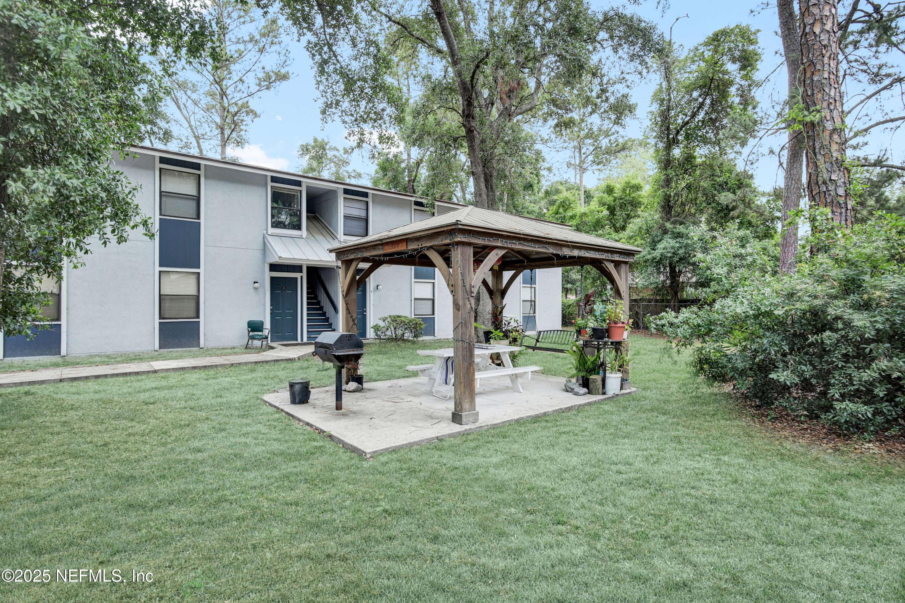 10825 Key Haven Boulevard, Unit 508 Jacksonville, FL 32218 - Photo 17 of 18 a view of a back yard with a table and chairs under an umbrella